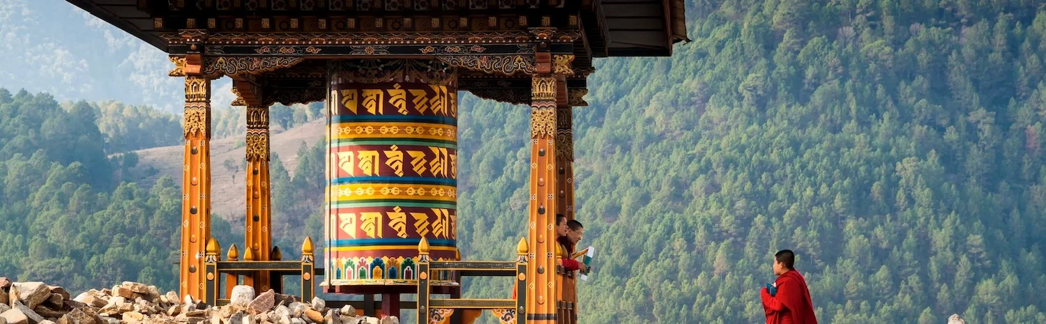 Traditional prayer wheel and mountain scenery near Trong Heritage Village